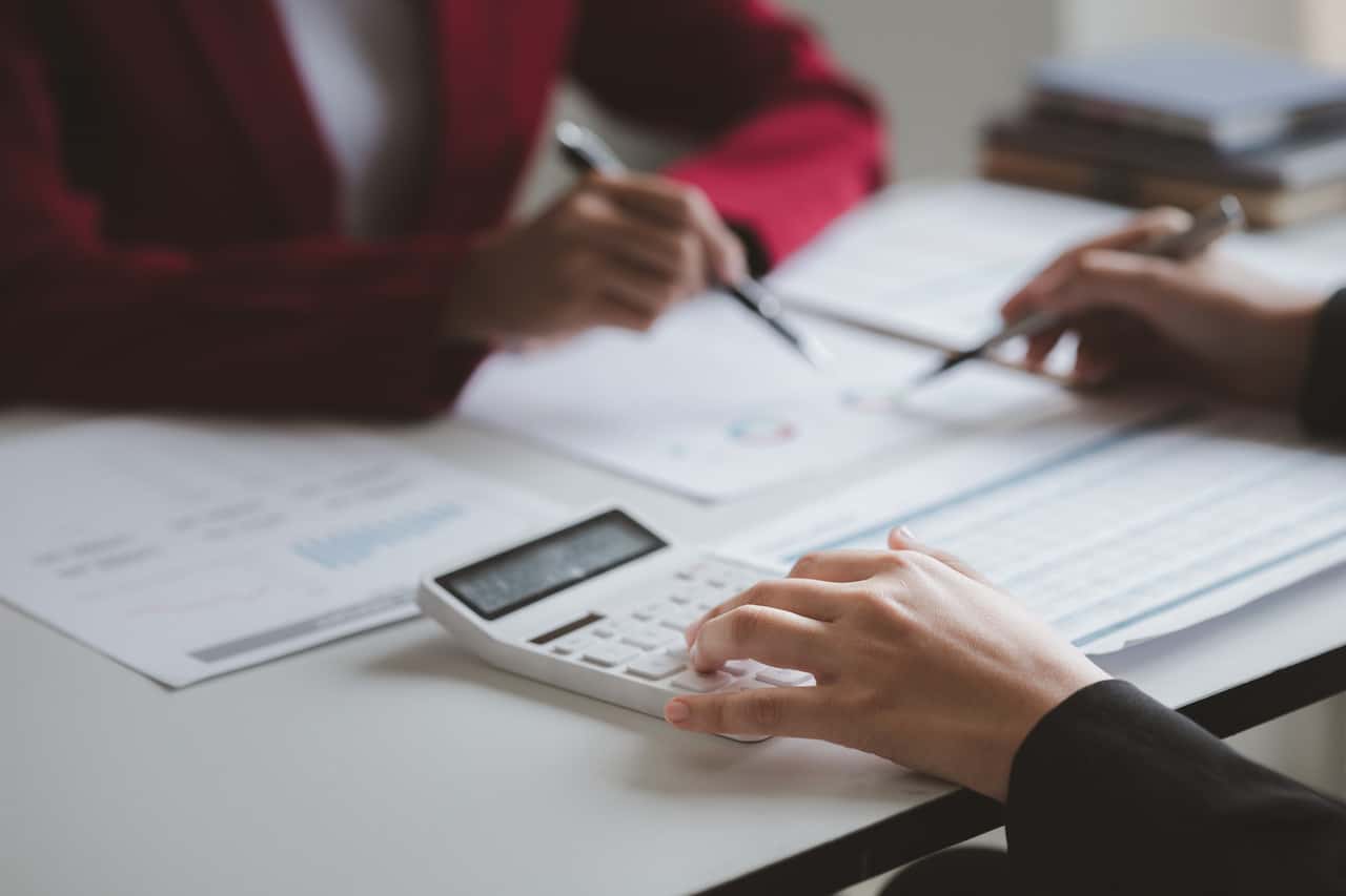 Two businessmen are brainstorming together and reviewing the company financial documents that the finance department has summarized, they are business partners. Business administration concept.