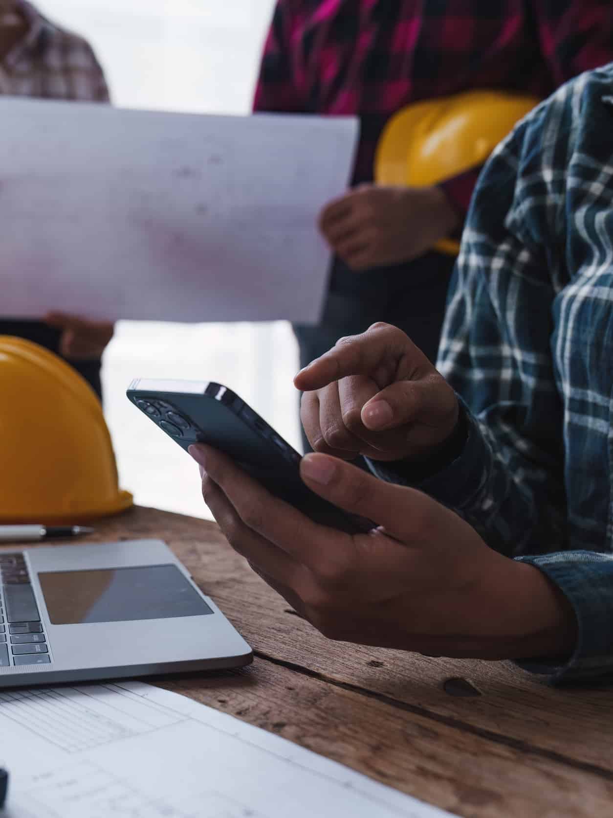 Architect and Engineer working with blueprints for architectural plan, engineer sketching a construction project, green energy concept